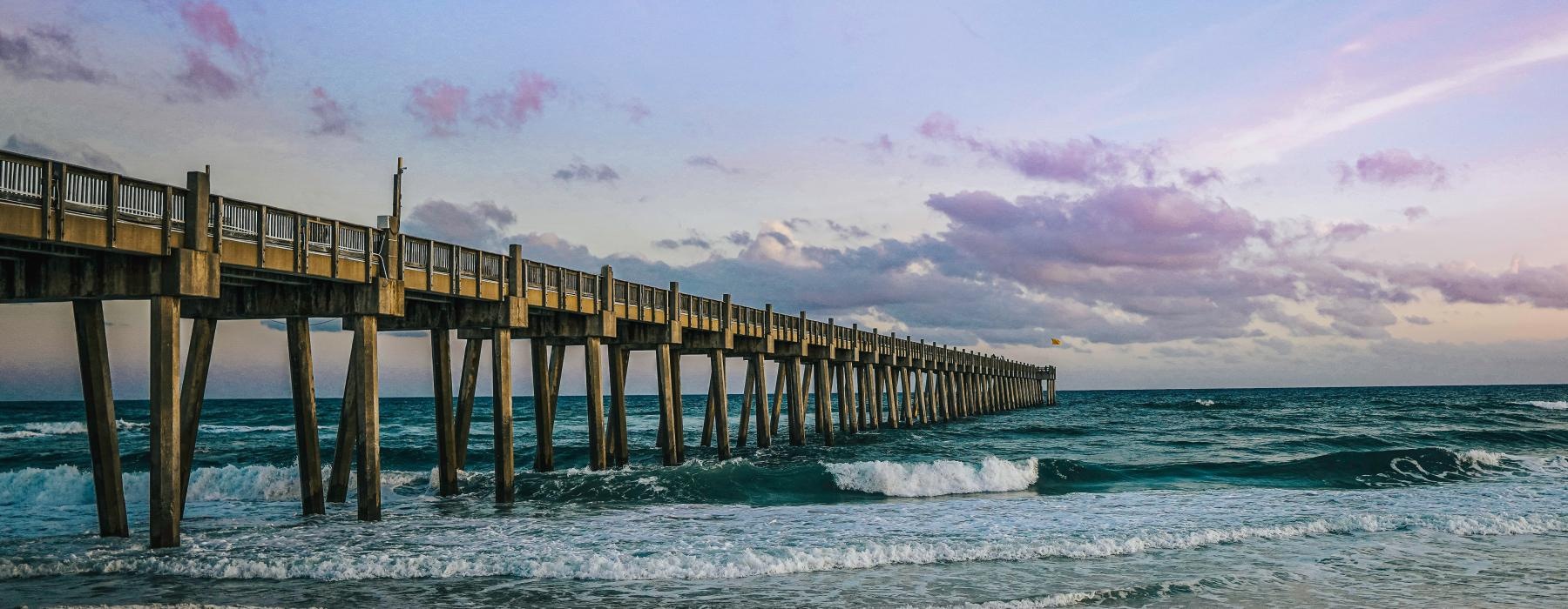 a long wooden pier over the ocean