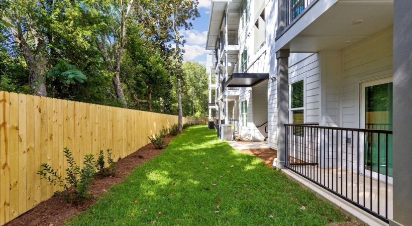 a fenced yard with a building and trees