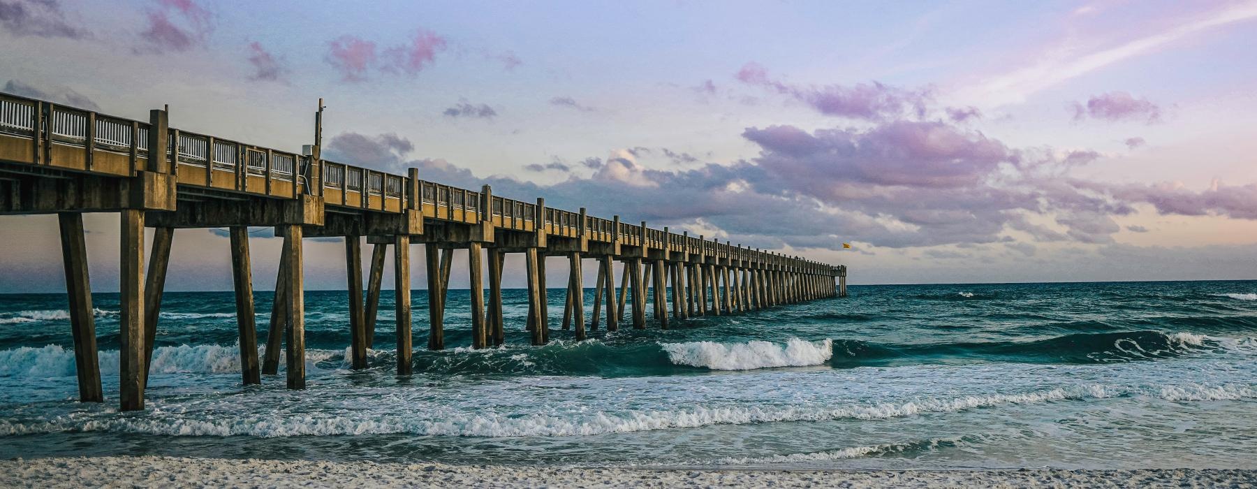 a long wooden pier over the ocean