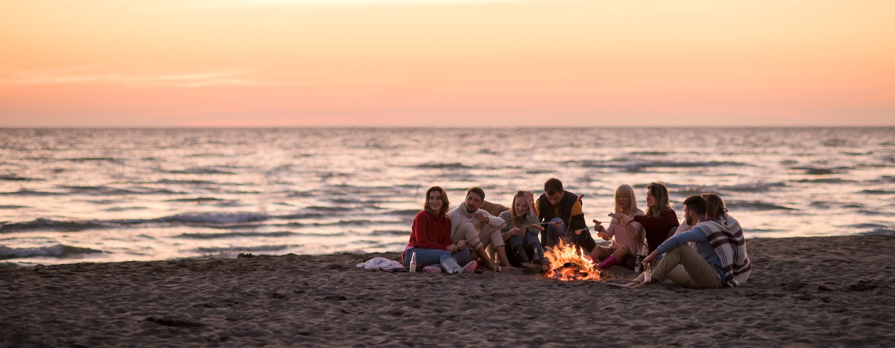 a group of people sitting on a beach